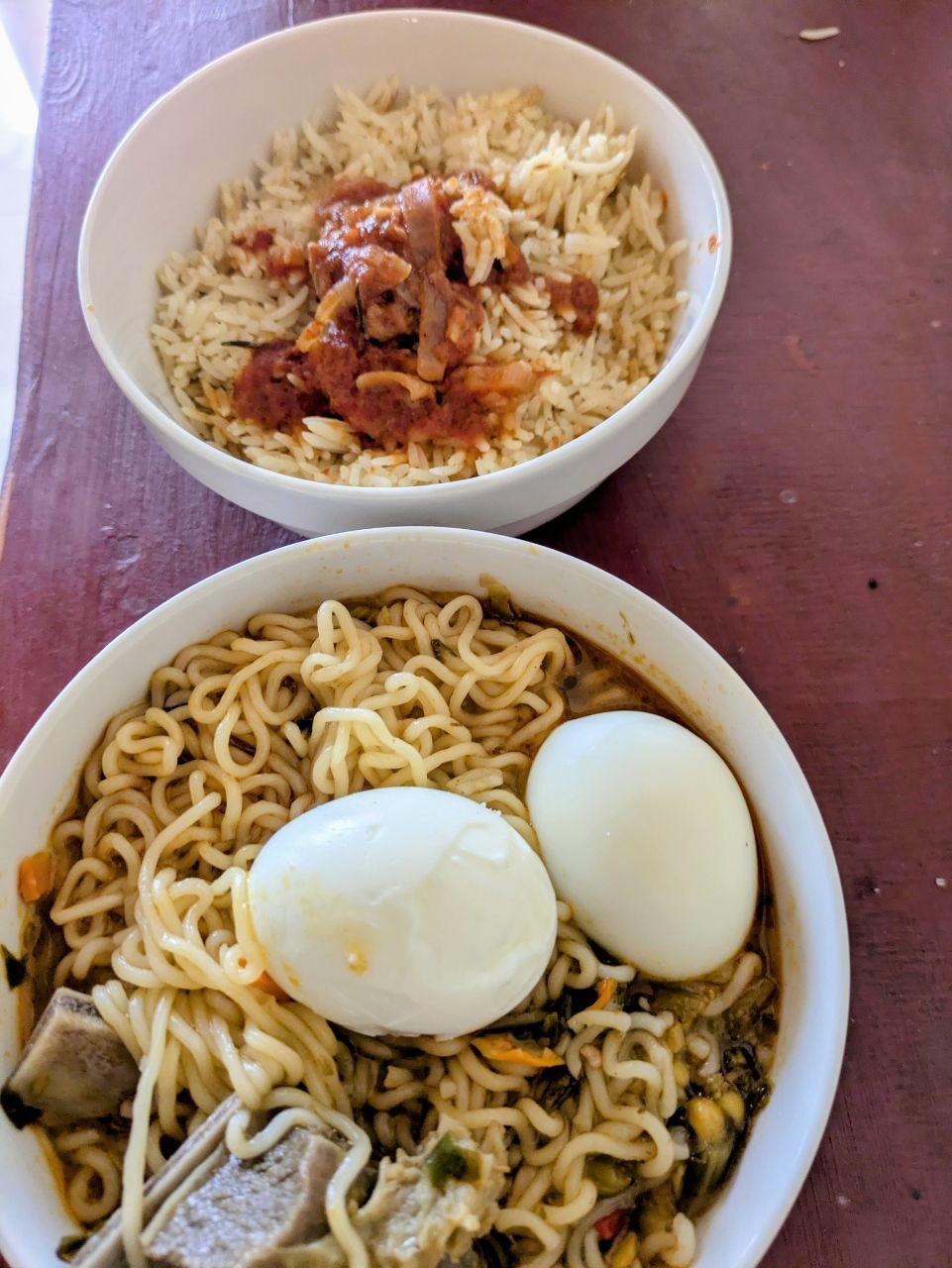Serving of chinese noodles in 2 bowls showing noodles and rice and boiled eggs