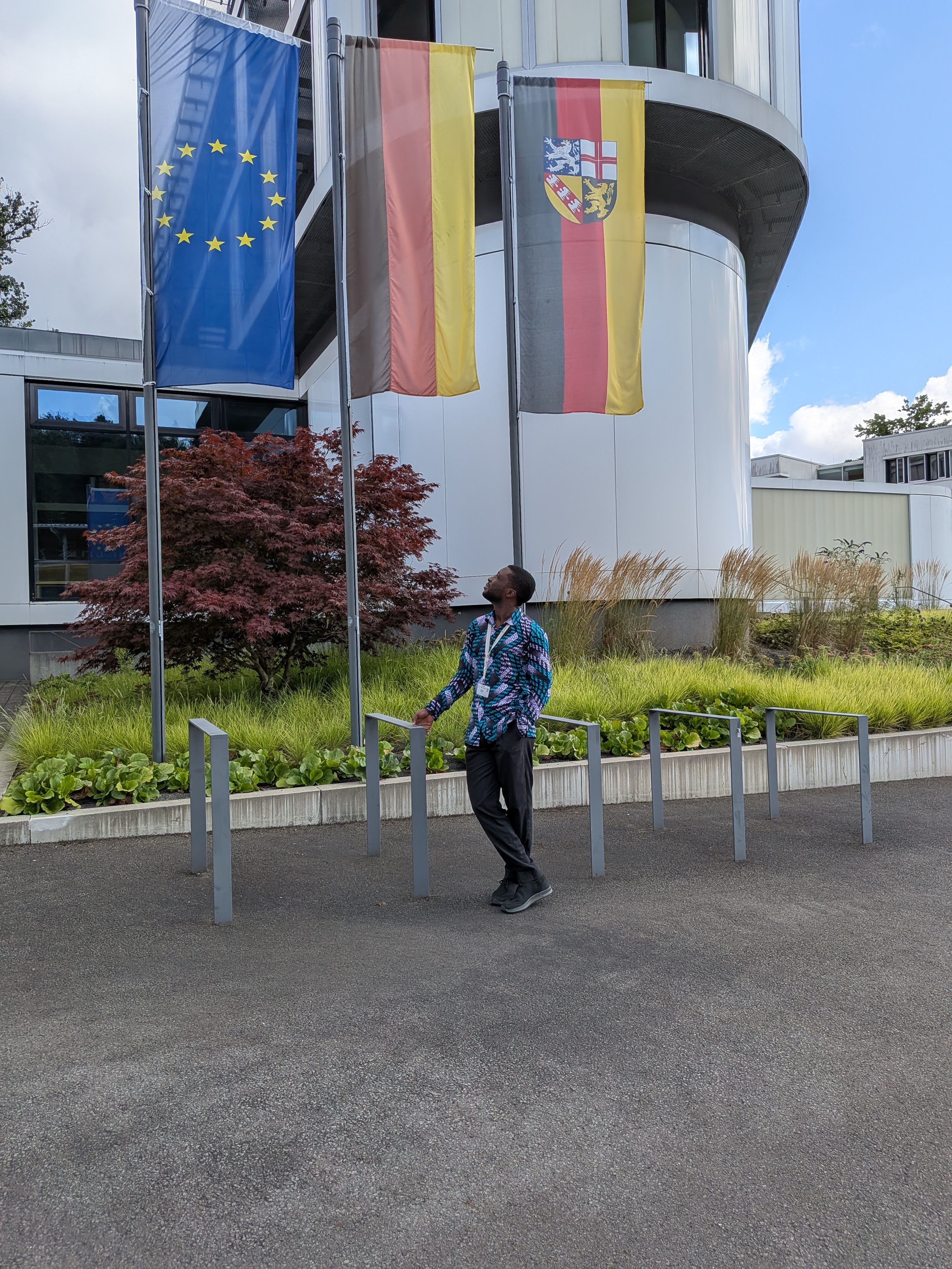 Richard Djarbeng in front of Germany and EU flags at MPI-SWI, CMMRS